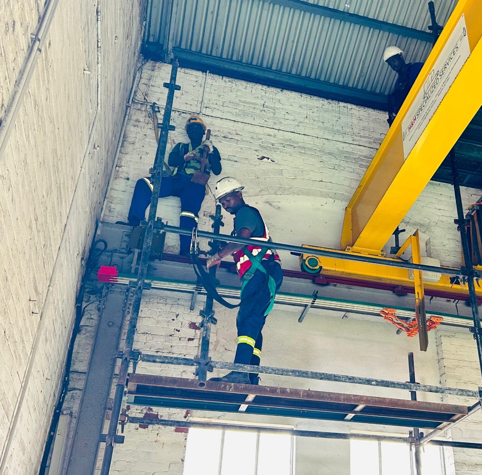 Afripact crew doing elevated industrial installation work, harnesses and hard hats